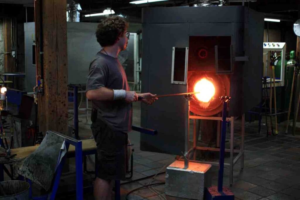 A glassblower in front of the kiln