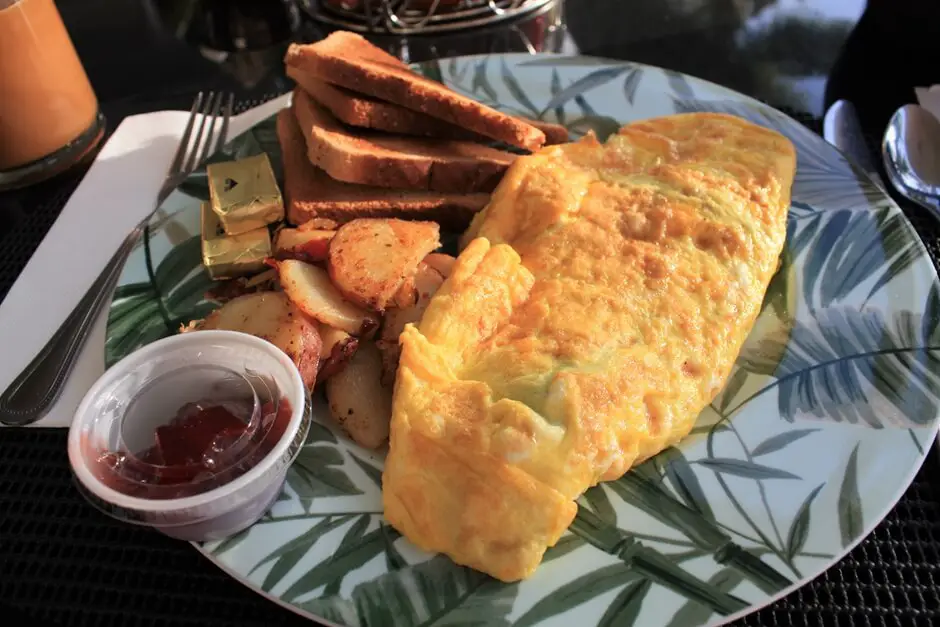 Frühstücksomelett mit Bacon, Spinat und Käse Amerikanisches Frühstück mit Eggs Benedict, Frühstück Omelette und Waffeln