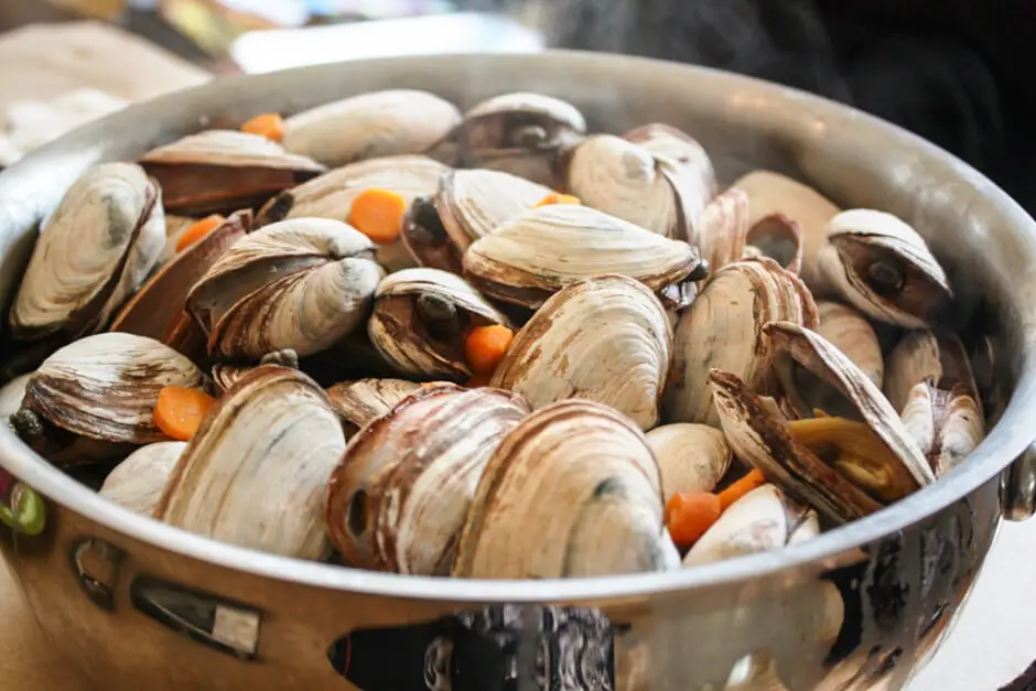 Ein Topf mit gekochten Muscheln und Karotten