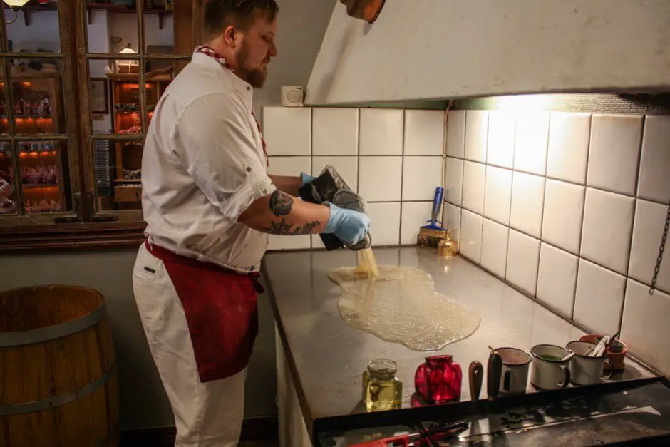 Isaac gießt die Zuckermasse auf die kalte Platte