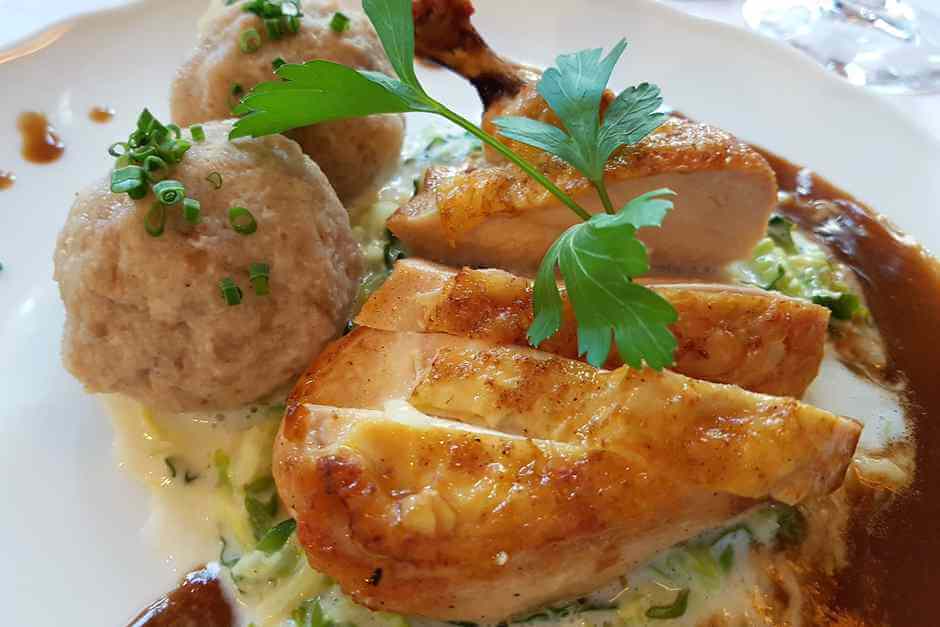 Chicken drumsticks with bread dumplings on a bed of vegetables in the Gasthof Zum Stern