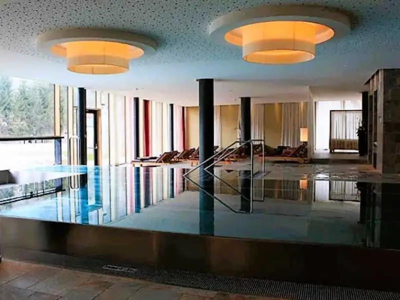 Bright light streams through the large window front into the interior of the pool area